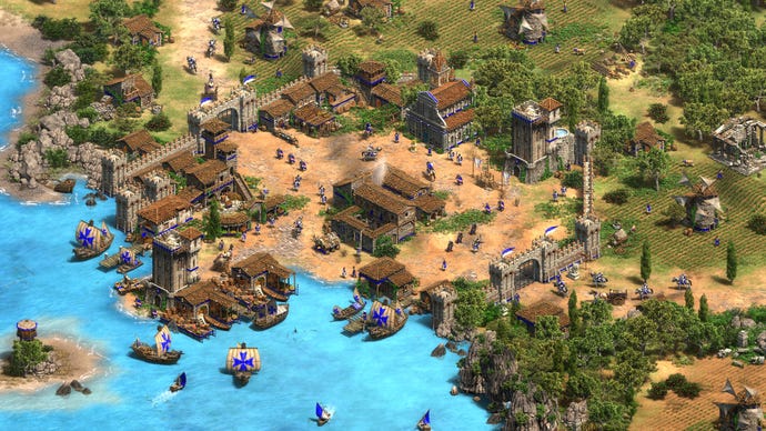 A screenshot of a settlement near a river in Age Of Empires II Definitive Edition